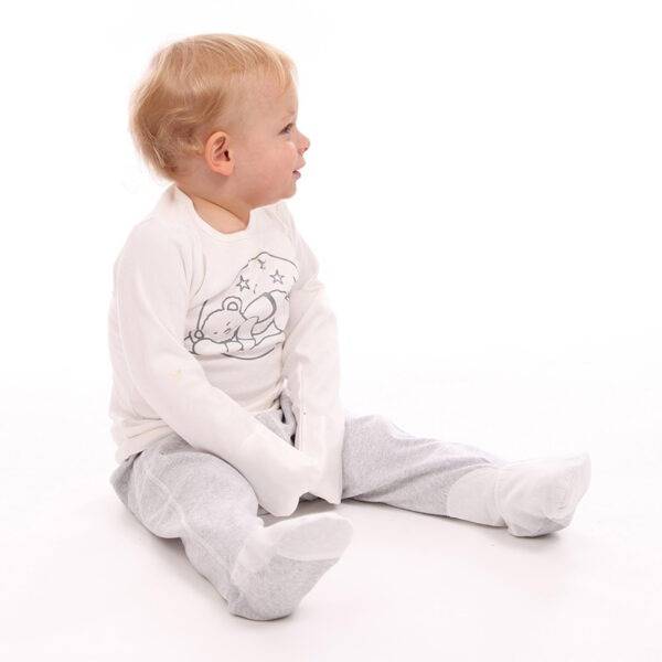 Little boy sat wearing ScratchSleeves grey toddlers sleepy bear pyjamas. Shows that the pyjama set is loose fitting with 100% cotton jersey fabric. Cute eczema pyjama set in neutral colours, with bear print, showing eczema clothing does not have to be boring.