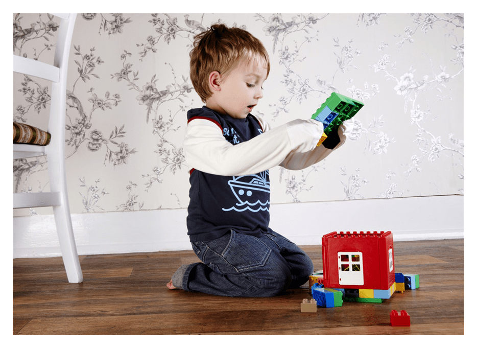 Young boy wearing ScratchSleeves playing with building blocks