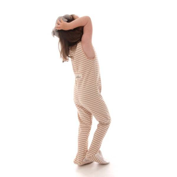 Little girl playing with teddy while wearing ScratchSleeves cappuccino striped dungarees. Eczema dungarees in a neutral colour, showing the fit is loose and comfortable and that eczema clothing does not have to be restrictive.