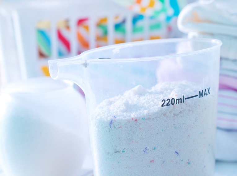 Laundry Detergent Powder and Blue Liquid Gel in Measuring Cup