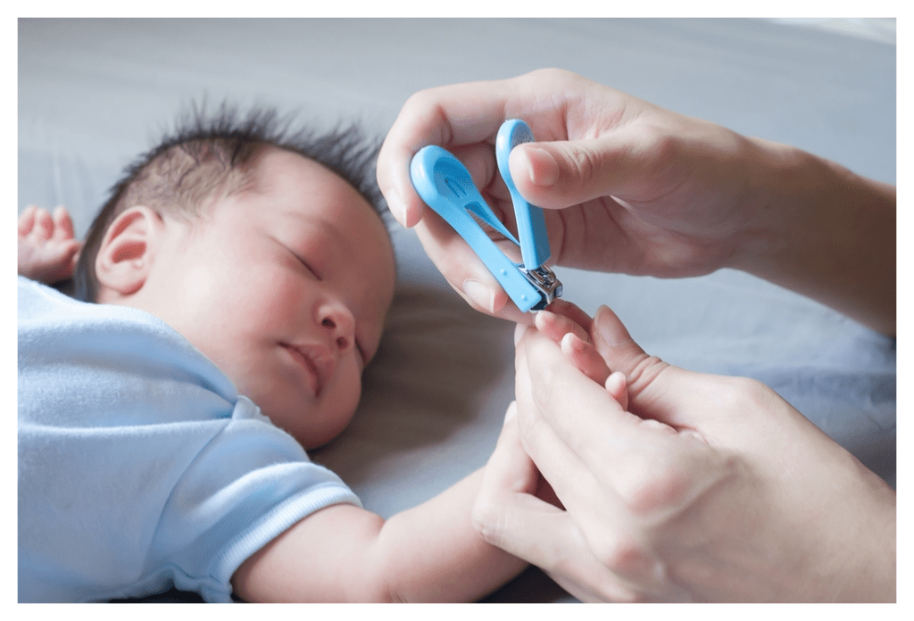 Parent cutting the finger nails of sleeping baby