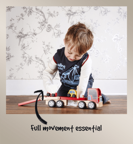 Little boy playing with wooden lorry while wearing ScratchSleeves, demonstrating how little these eczema scratch mittens restrict movement and dexterity